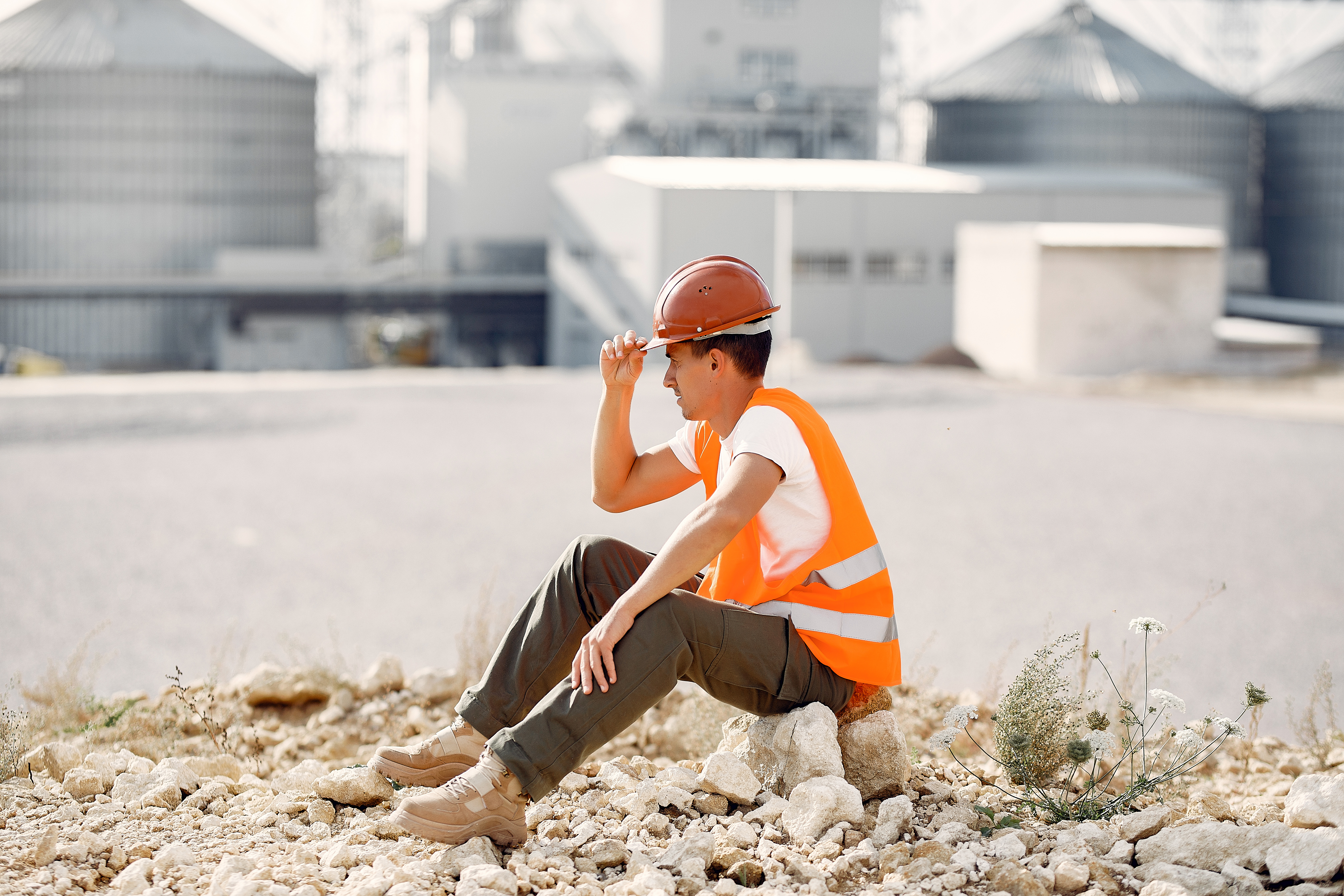 Engineer in a helmet sitting by the factory
